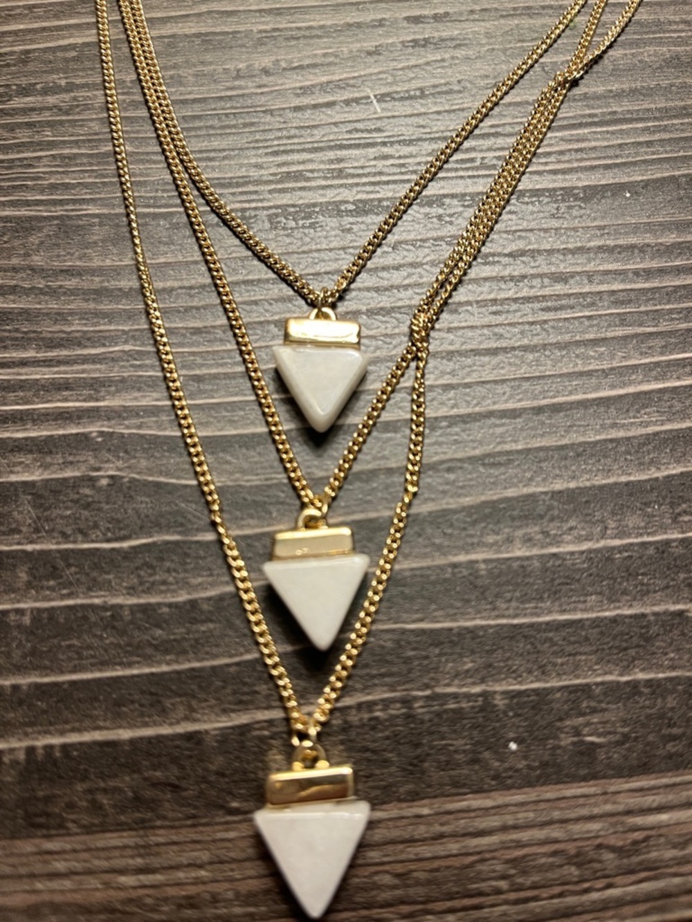 The Limited three chained gold tone long necklace. Each has a white stone.
